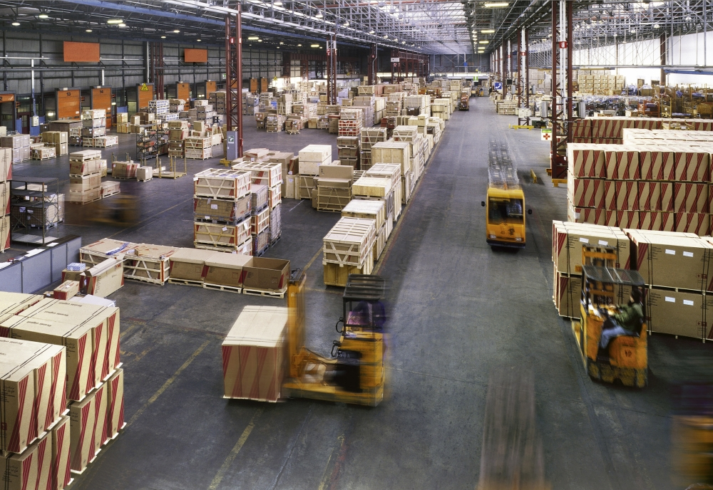 Professional movers handling heavy machinery in a warehouse for an industrial move